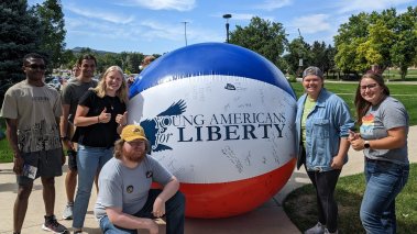 Members of Young Americans for Liberty at Black Hills State University standing in front of a giant beach ball