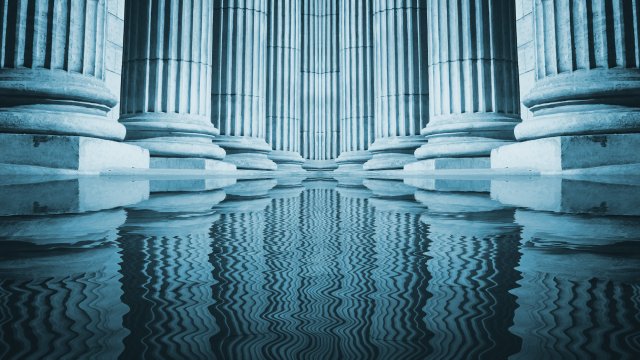 Close up of a bright classical pillars reflecting in a pool of water