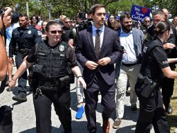Christopher Rufo is escorted away from protesters by police