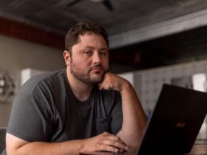 Anthony Novak sits at his computer