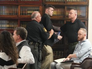 Derek Myers of the Scioto Valley Guardian is escorted out of the courtroom