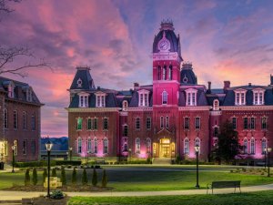 Woodburn Hall at West Virginia University or WVU in Morgantown WV as the sun sets behind the illuminated historic building