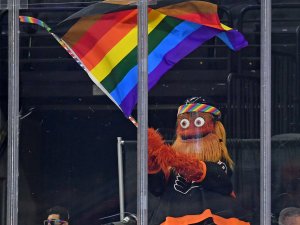 Philadelphia Flyers mascot Gritty waves a flag during Pride Night against the Pittsburgh Penguins