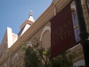 Texas State University banner and Old Main building in San Marcos