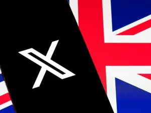 X logo on smartphone screen over British flag