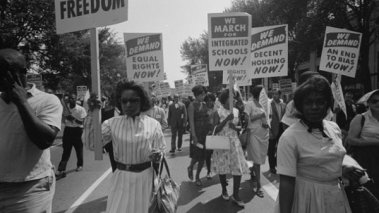 Photo of African American women at the March on Washington on 28 August 1963 carrying signs for equal rights, integrated schools, decent housing, and an end to bias.