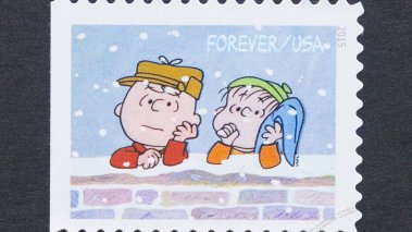 Charlie Brown and Linus leaning up on a brick wall.