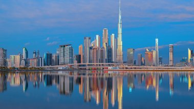 View on Dubai skyline with reflection in the river at sunrise, Dubai, United Arab Emirates