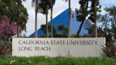 Entrance of California State University Long Beach with sign and a view of Walter Pyramid sports arena.