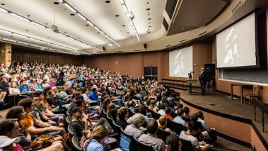 Professor Neil Shubin delivers a lecture to a large audience of college students at the University of Texas at Austin.