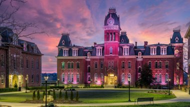 Woodburn Hall at West Virginia University or WVU in Morgantown WV as the sun sets behind the illuminated historic building