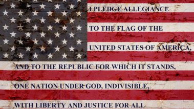 The pledge of allegiance written on a weathered United States of America flag 