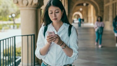 Stanford University student checking mobile phone notifications