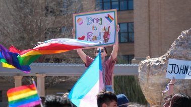 A student holds up a sign reading "drag is rad" in protest at West Texas A&M University in response to the president canceling an on-campus drag show.