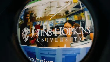 Johns Hopkins University website on laptop screen displayed with grainy default from old camera