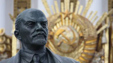 Statue of Vladimir Lenin with Communism logo fade out in background