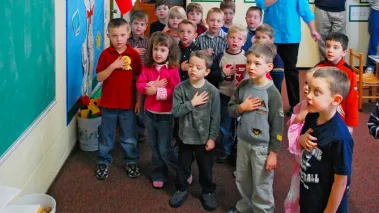 students stand to recite pledge of allegiance