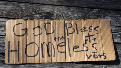 Cardboard sign saying "God bless homeless vets"