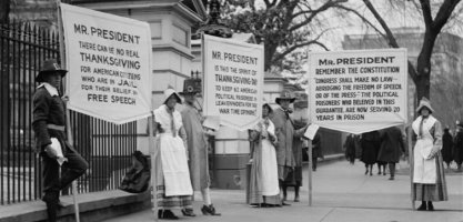 Protesters dressed as pilgrims carry signs calling for amnesty for political prisoners standing in front of the White House, circa 1918.