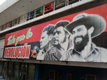 Propaganda poster in Havana, Cuba, circa 2012, featuring revolution-era photos of (left to right) Camilo Cienfuegos, Ernesto "Che" Guevara, and Fidel Castro.