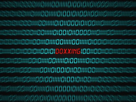 Computer screen with binary code and the word DOXXING in red