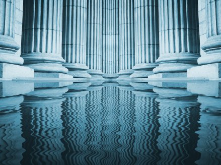 Close up of a bright classical pillars reflecting in a pool of water