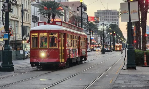 Red streetcars gliding along Canal Street weaving through the heart of downtown New Orleans