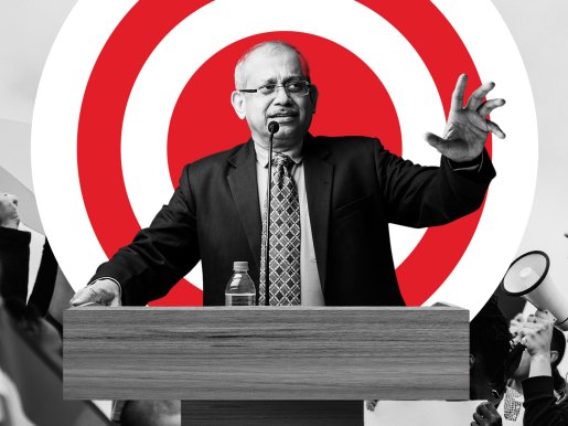 Man at a podium standing in front of a red bullseye 