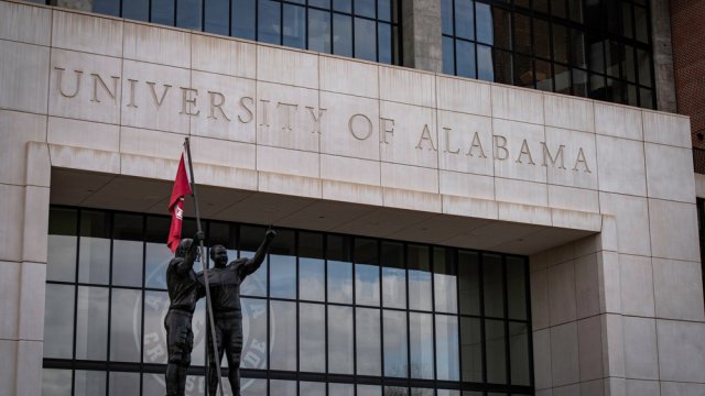 Bryant-Denny NCAA Football Stadium with statues and flag at the University of Alabama