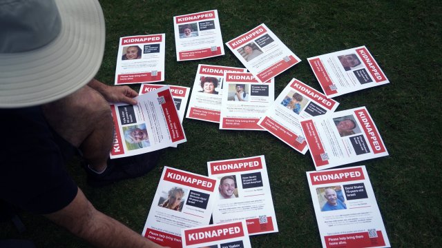 Shay Zaidenberg shows flyers of kidnapped Israelis on Sunday afternoon on the Great Lawn in West Palm Beach.