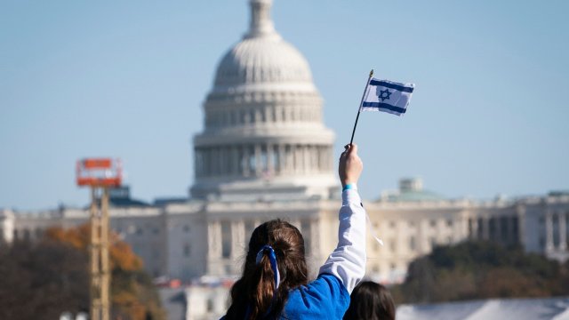 A child waves the flag of Israel at a rally during the March for Israel in Washington on the National Mall 