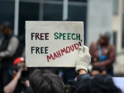 Protester holding a sign that reads Free Speech Free Mahmoud March 12 2025